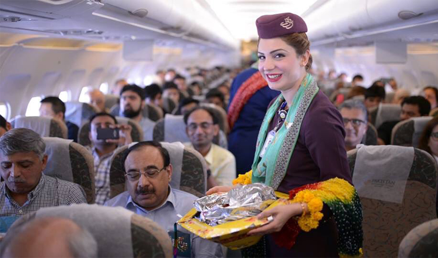 In this photo, a Pakistani air hostess serves food to passengers on a Pakistan International Airlines on March 7, 2018. (PIA Twitter/FILE)
