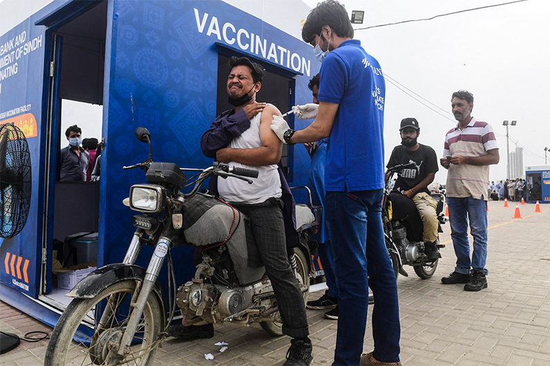 A man receives a dose of the Sinopharm vaccine against the Covid-19 coronavirus, during a drive-through vaccination in Karachi on July 26, 2021. (AFP/FILE)