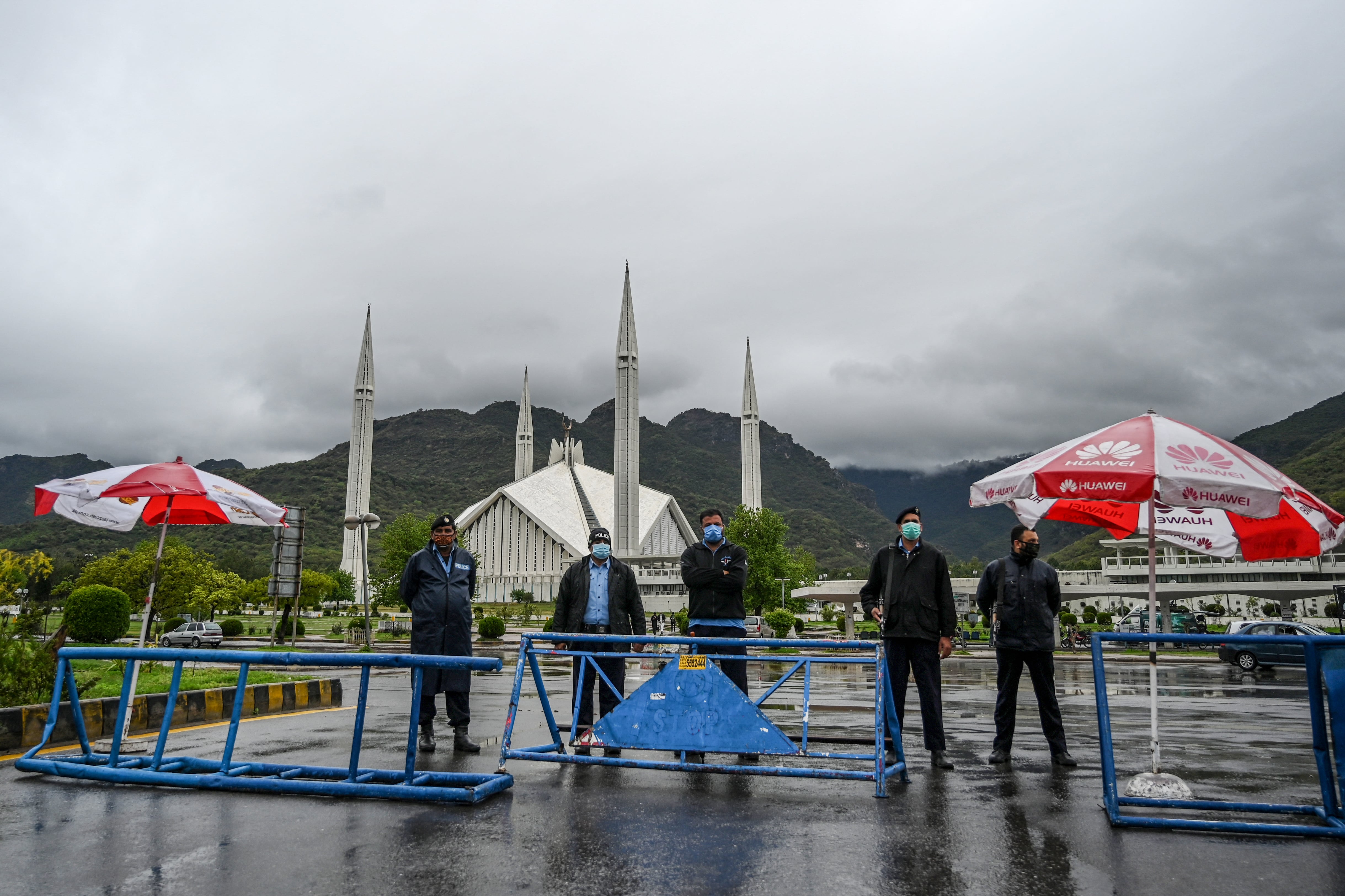 Policemen wearing facemasks stand guard at a checkpoint beside the Grand Faisal Mosque during a government-imposed nationwide lockdown as a preventive measure against the COVID-19 coronavirus, in Islamabad on March 27, 2020. (AFP/ File)