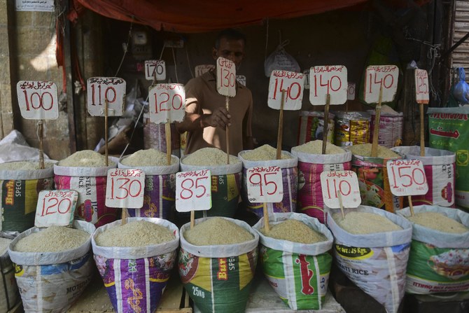 A shopkeeper fixes the price tag of rice at his shop in a market in Karachi on June 10, 2021. (AFP/ File)