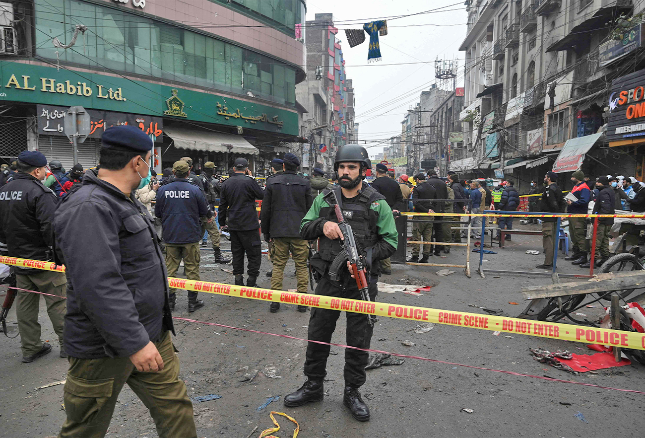 Security officials cordon off the site of a bomb blast that killed two people and wounded 22 others at a busy shopping district in Lahore, Pakistan, on January 20, 2022. (AFP)