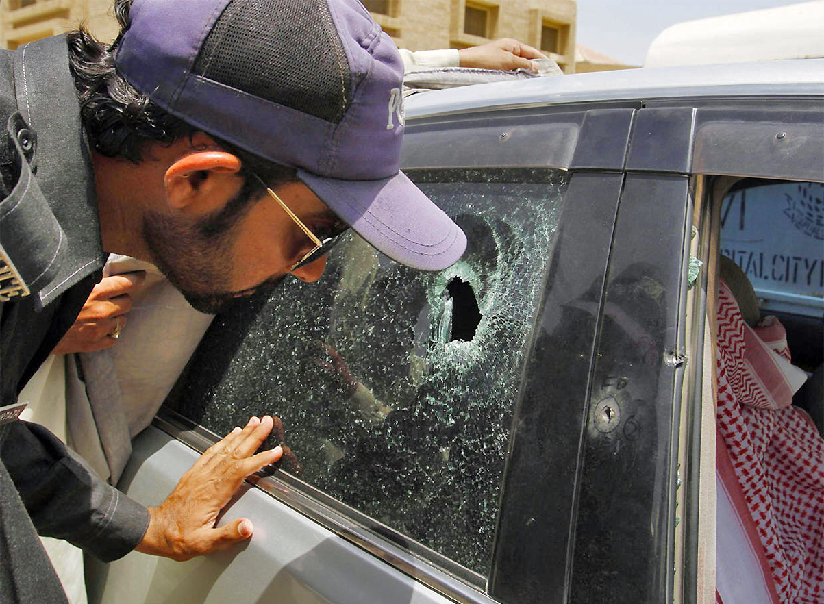 A Pakistani police officer examines a bullet hole on the car of a Saudi consulate diplomat who was shot dead in Karachi, Pakistan, on May 16, 2011. (AP/File)