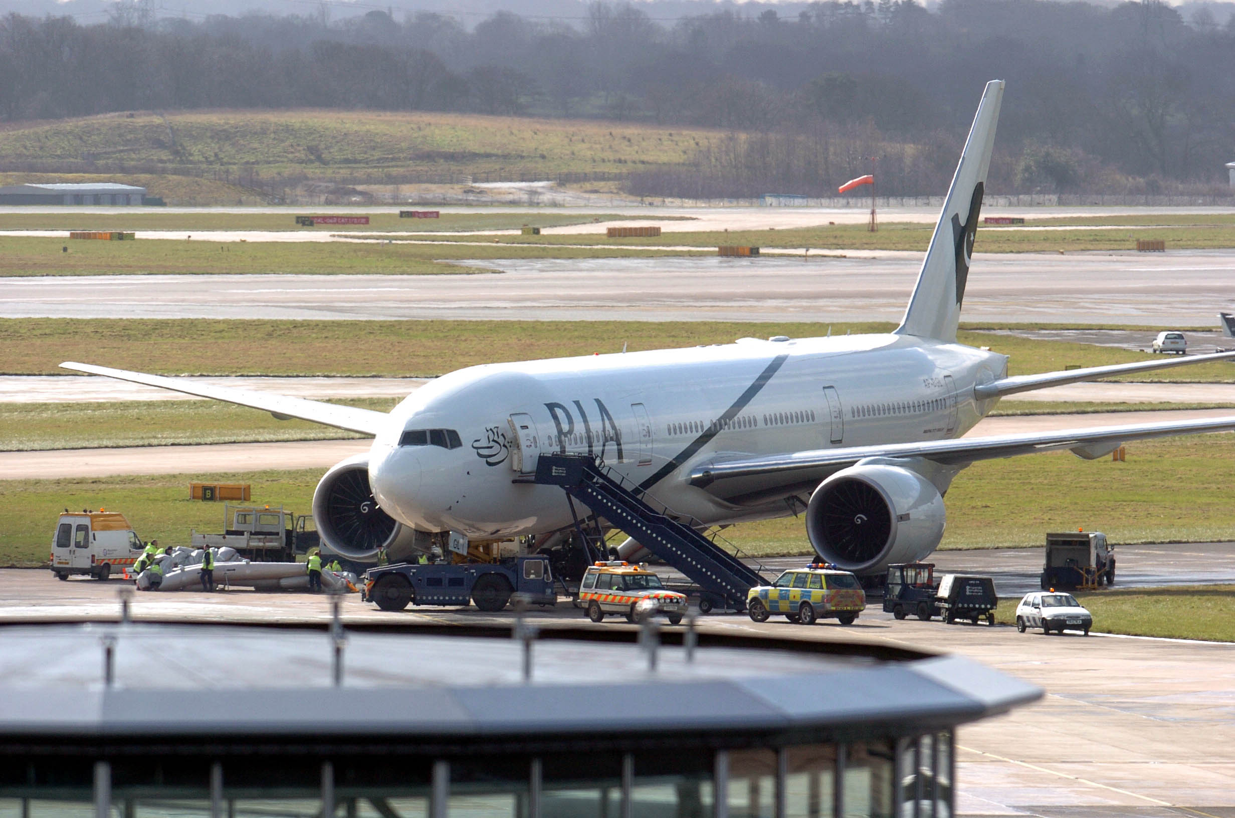Ground crews remove an emergency escape chute after a Pakistan Airlines plane was evacuated following a fire at Manchester Airport, 01 March 2005.(AFP/ File)