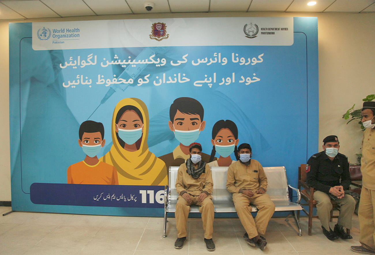 People wait their turn to receive the dose of COVID-19 vaccine at a vaccination center, in Peshawar, Pakistan, on January 21, 2022. (AP)