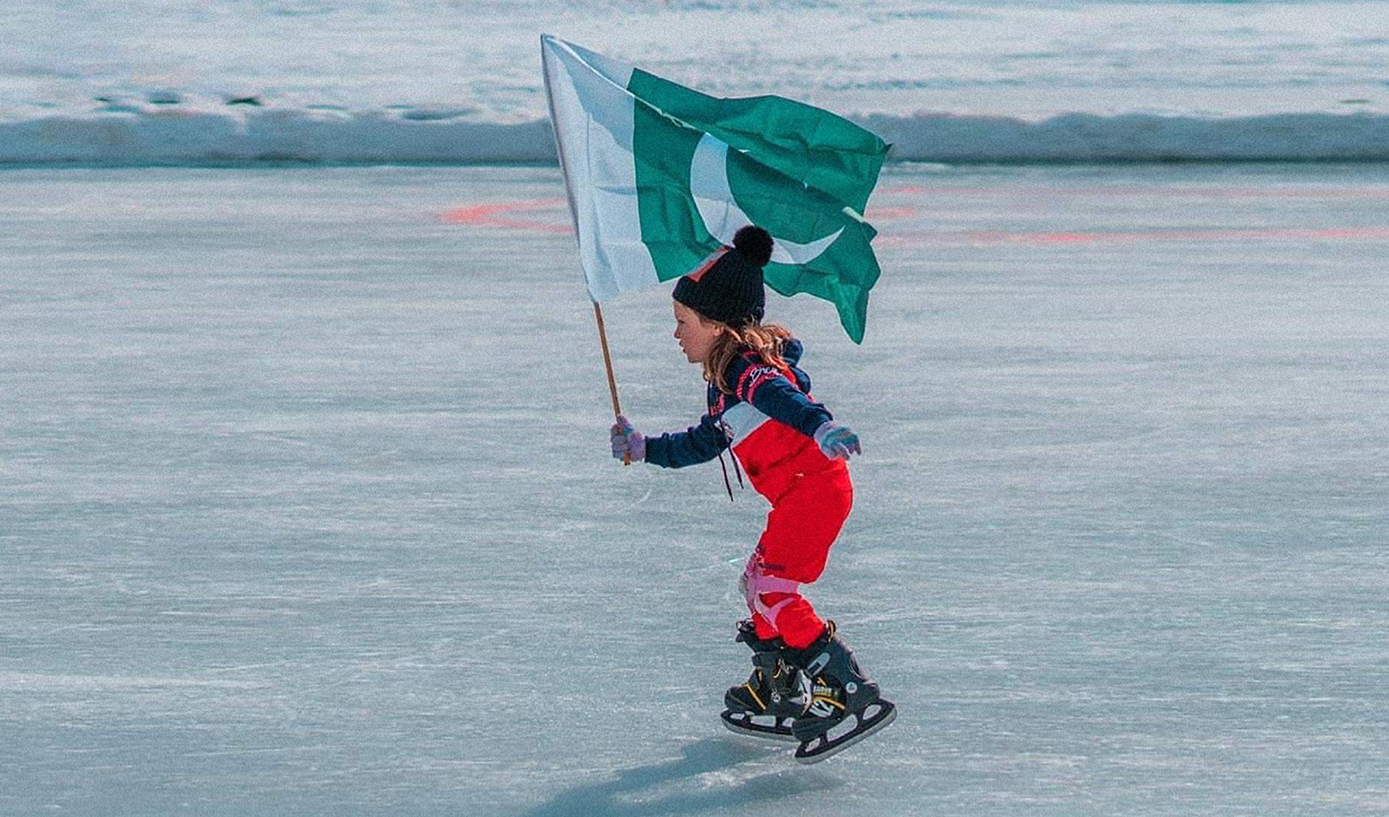 A girl waves the national flag of Pakistan on an ice rink in Skardu district, Gilgit-Baltistan, Pakistan, on January 25, 2022. (Photo courtesy: Pamir Times)