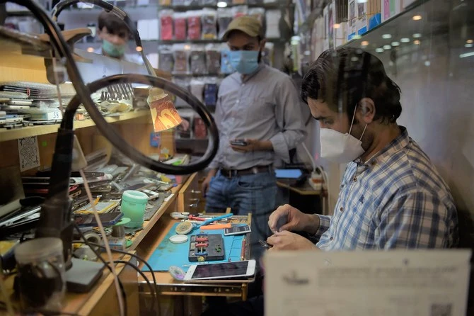 A shopkeeper repairs a mobile phone at his shop after the government eased the nationwide lockdown imposed as a preventive measure against the COVID-19 coronavirus, in Rawalpindi on May 11, 2020. (AFP/ File)