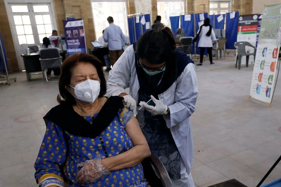 A woman receives the first dose of the coronavirus disease (COVID-19) vaccine, as the government started vaccination for the general public, starting with elderly people, at a vaccination center in Karachi, Pakistan March 10, 2021. (REUTERS)