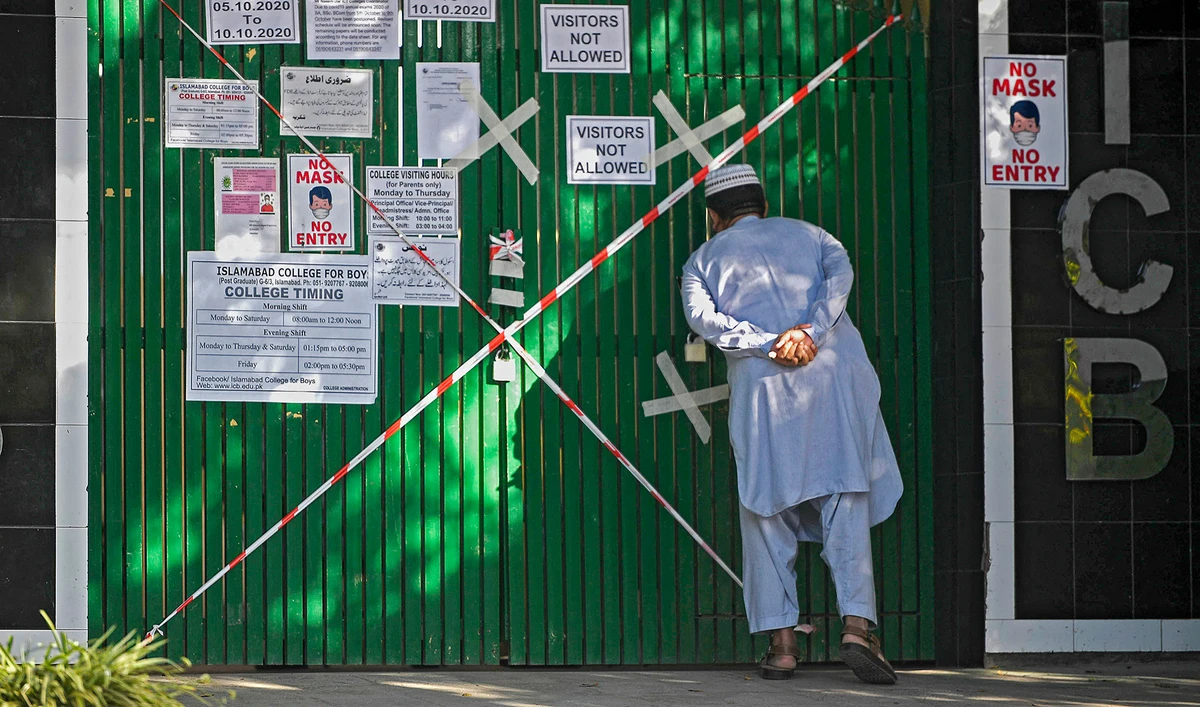 A man looks inside from a closed gate of a school sealed by authorities as some teachers and students tested positive for the Covid-19 Coronavirus in Islamabad on October 5, 2020. (AFP/File)