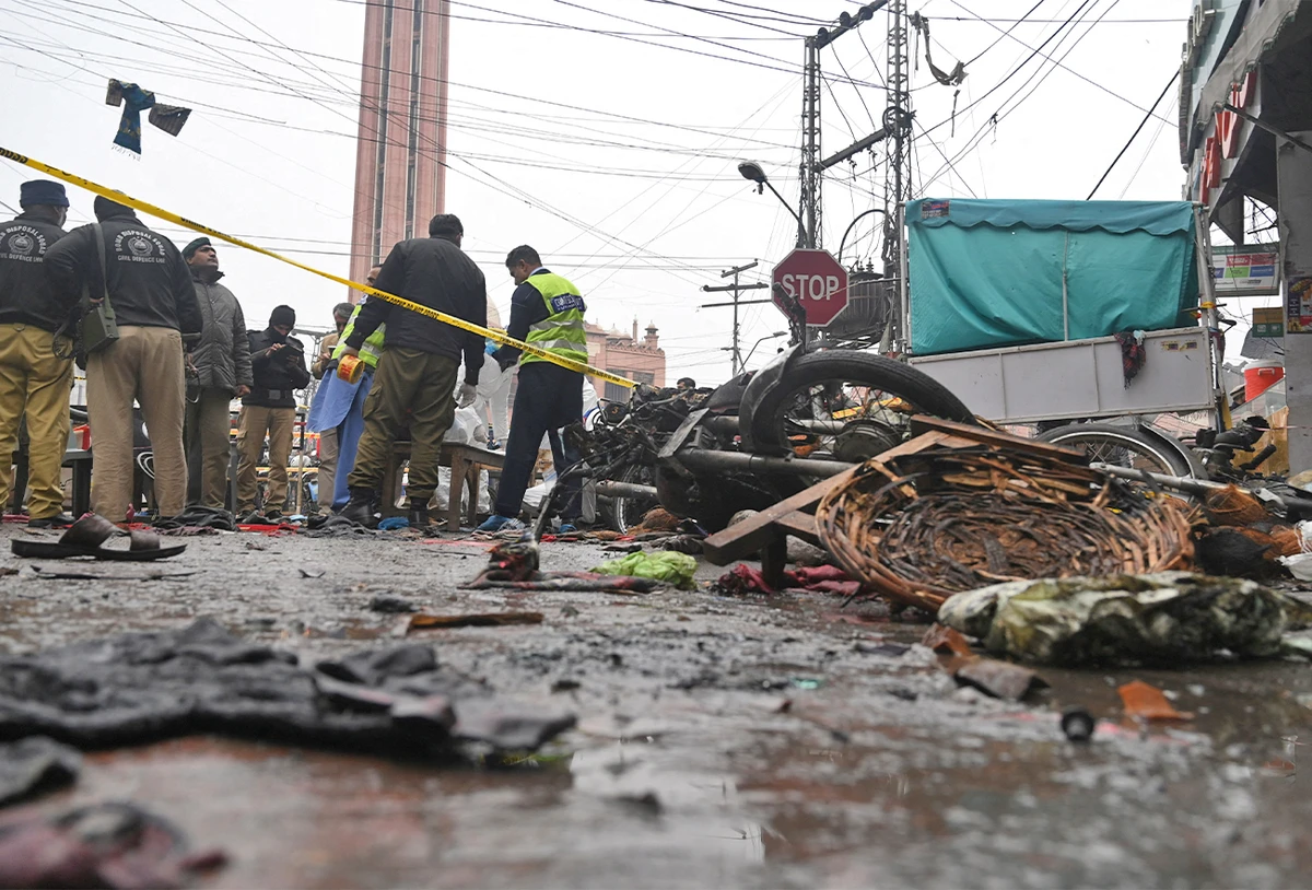 Security officials inspect the site of a bomb blast that killed two people and wounded 22 others at a busy shopping district in Lahore, Pakistan, on January 20, 2022. (AFP)