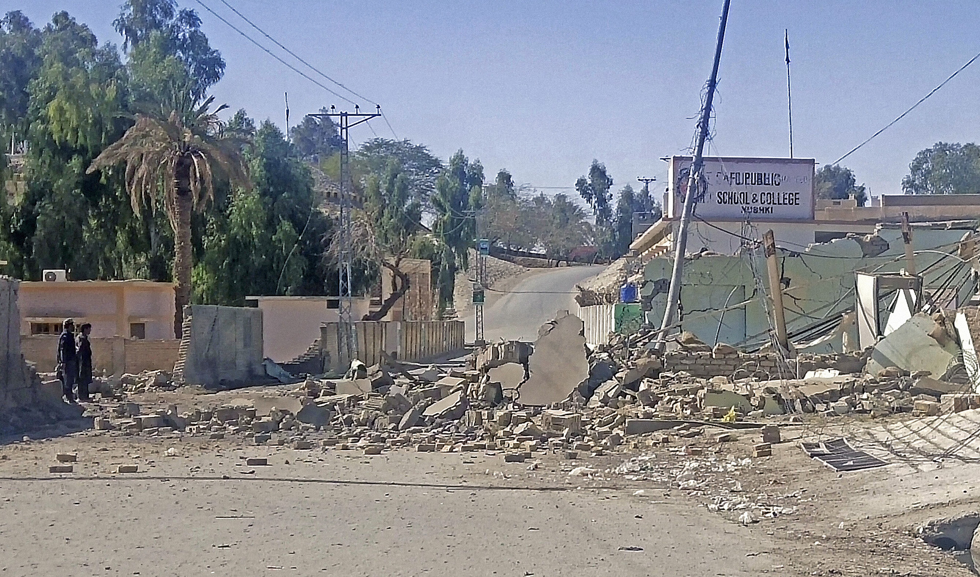 Security personnel stand beside a destroyed security post following overnight attacks by militants on security camps in Naushki district of Pakistan's Balochistan province on February 3, 2022. (AFP)
