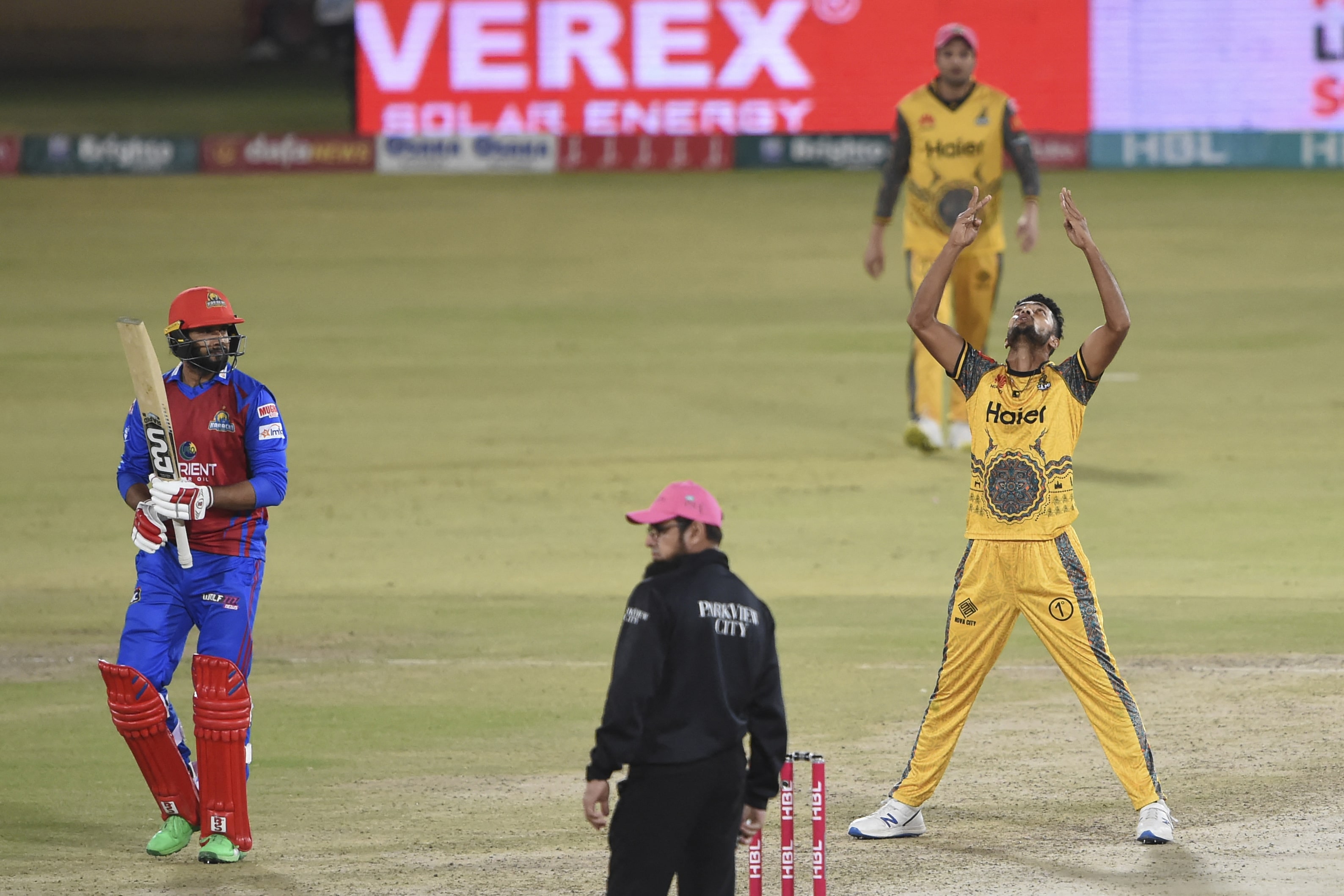 Peshawar Zalmi's Mohammad Umar (R) celebrates after taking the wicket of Karachi Kings'Imad Waseem (L) during the Pakistan Super League (PSL) Twenty20 cricket match between Karachi Kings and Peshawar Zalmi at the National Cricket Stadium in Karachi on February 4, 2022. (AFP)