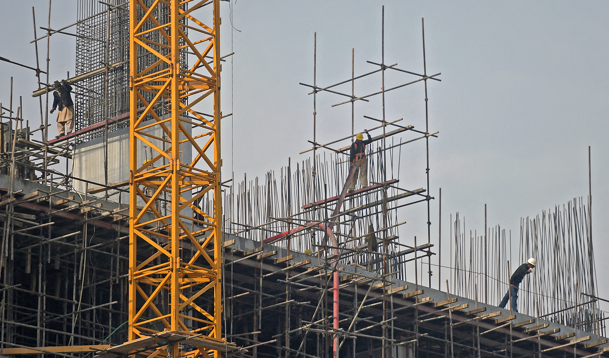 Pakistani laborers work on an under-construction multiple storey building in Islamabad on January 23, 2017. (AFP/File)