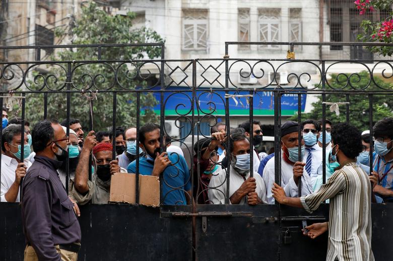 Residents gather to receive a dose of coronavirus disease (COVID-19) vaccine, after government warned of penalties for the unvaccinated, outside a vaccination facility in Karachi, Pakistan August 4, 2021. (REUTERS)