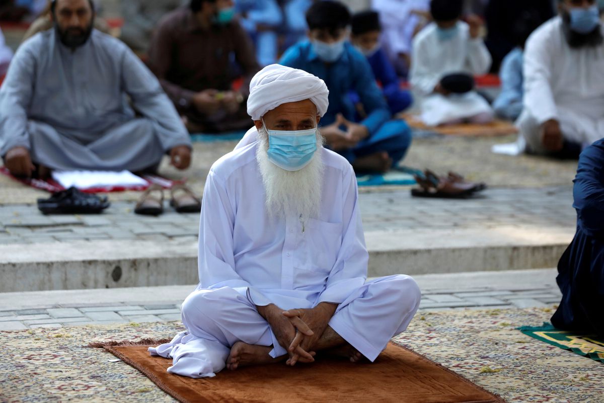 A man wears protective mask maintaining social distance with others as they gather to celebrate Eid al-Fitr prayers to mark the end of the holy fasting month of Ramadan, as the outbreak of the coronavirus disease (COVID-19) continues in Peshawar, Pakistan May 13, 2021. (REUTERS)