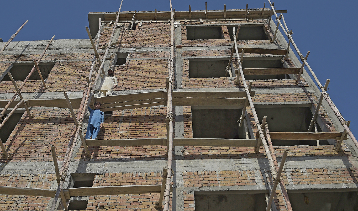 Laborers work on an under construction house on the outskirts of Islamabad, Pakistan, on June 14, 2020. (AFP/File)