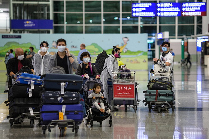 Newly arrived passengers wear protective gear and facemask as a precautionary measure against the COVID-19 coronavirus, at the arrivals hall of Hong Kong’s international airport on March 24, 2020. (AFP/FILE)