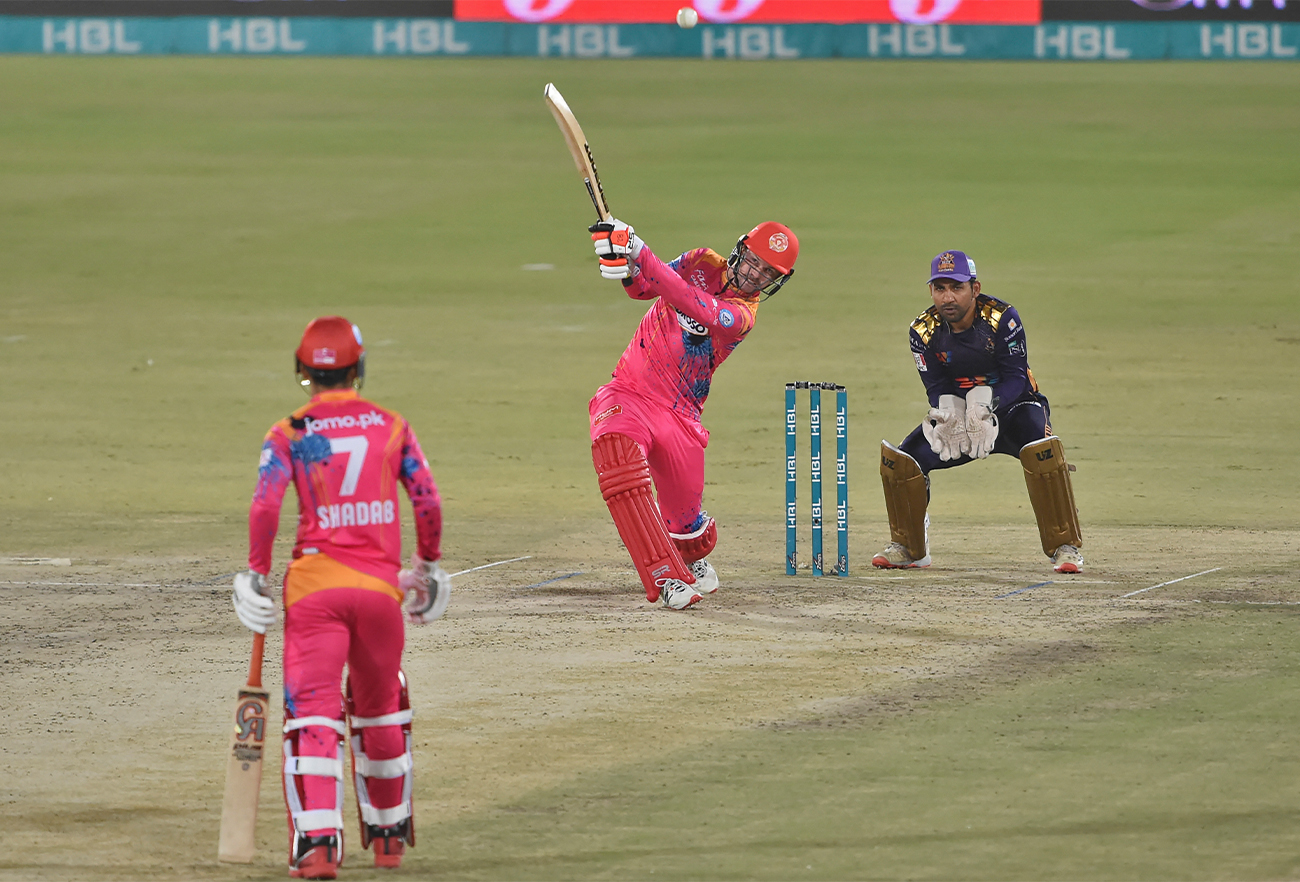 Islamabad United's Colin Munro (C) plays a shot as Quetta Gladiators' captain wicketkeeper Sarfraz Ahmed (R) watches during the PSL T20 cricket match between Quetta Gladiators and Islamabad United in Karachi, Pakistan, on February 3, 2022. (AFP/File)