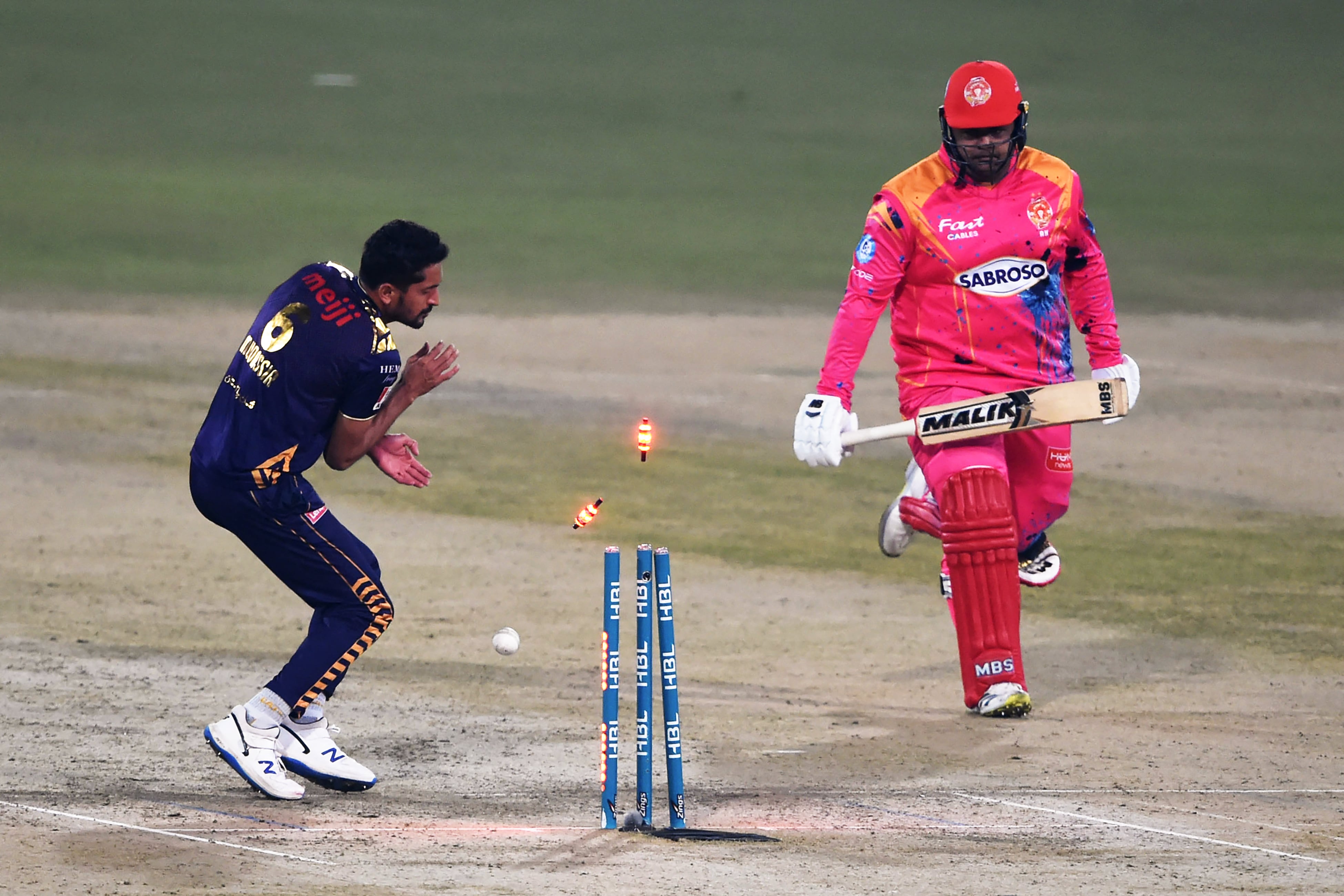 Islamabad United's Azam Khan (R) is runs out during the Pakistan Super League (PSL) Twenty20 cricket match between Quetta Gladiators and Islamabad United at the Gaddafi Cricket Stadium in Lahore on February 12, 2022. (AFP)