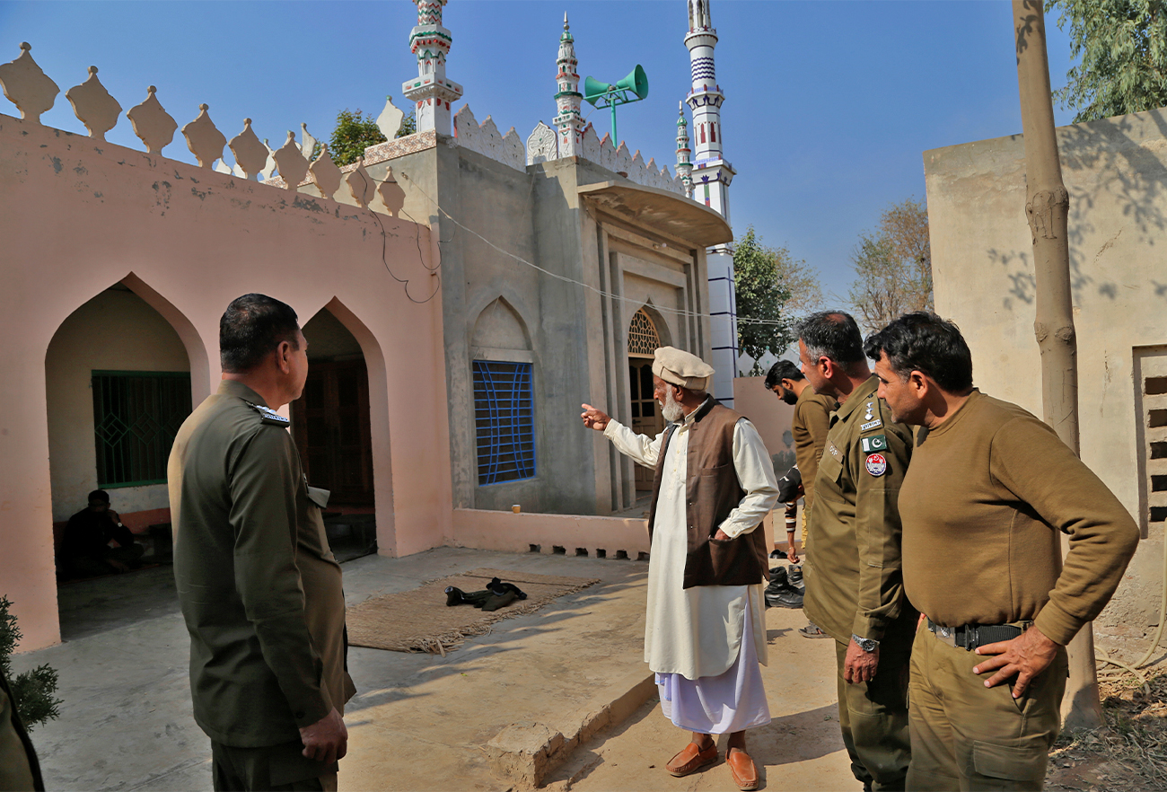 Mian Mohammad Ramzan, center, the mosque custodian, gestures as he briefs police officers regarding the stoning to death of Mushtaq Ahmed, 41, by an angry mob for allegedly desecrating the Quran, in Tulamba, Pakistan, on Feb. 13, 2022. (AP)
