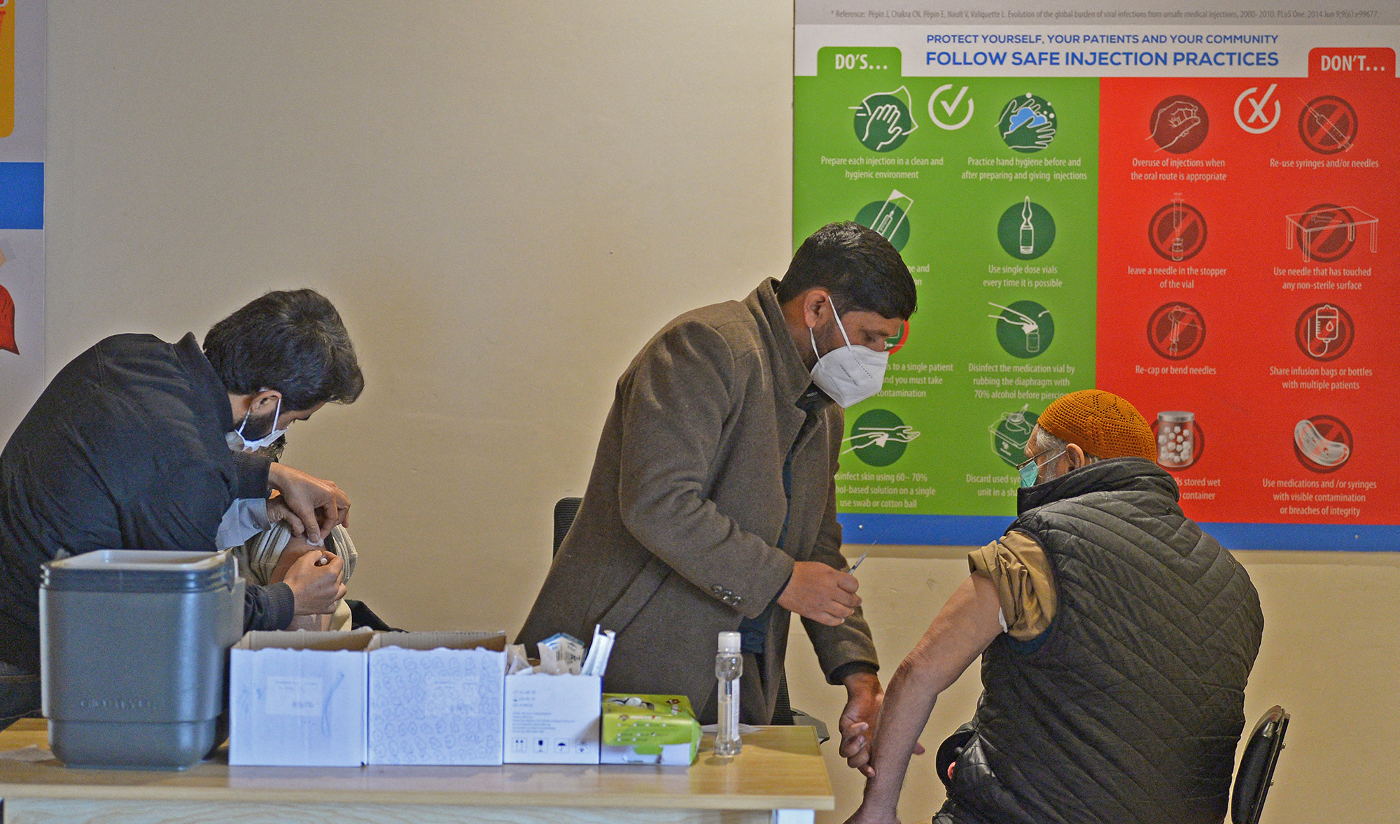Health workers inoculate men with a dose of the Covid-19 coronavirus vaccine in Islamabad on January 4, 2022. (AFP/File)
