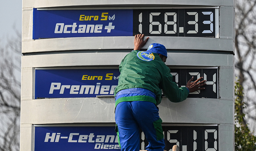An employee of a fuel station updates the latest fuel price list in Islamabad on February 16, 2022, after a hike in prices of petroleum products. (AFP)