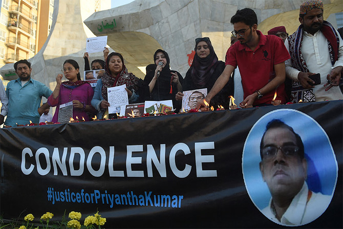 Members of the Human Rights Council of Pakistan place earth oil lamp to pay tribute beside a photograph of late Sri Lankan factory manager, in Karachi on December 5, 2021. (AFP)