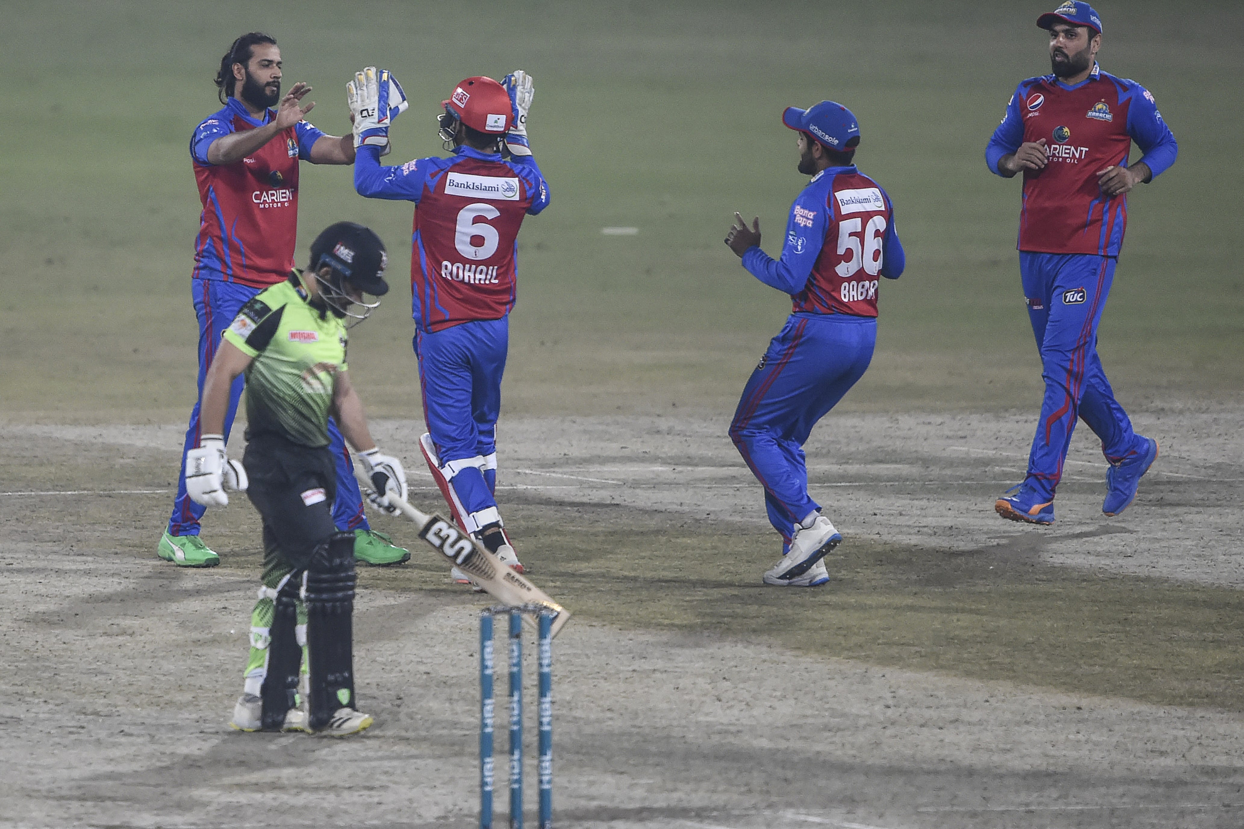 Karahci Kings' players celebrate after the dismissal of Lahore Qalandars' Kamran Ghulam (L) during the Pakistan Super League (PSL) Twenty20 cricket match between Lahore Galandars and Karachi Kings at the Gaddafi Cricket Stadium in Lahore on February 18, 2022. (AFP)