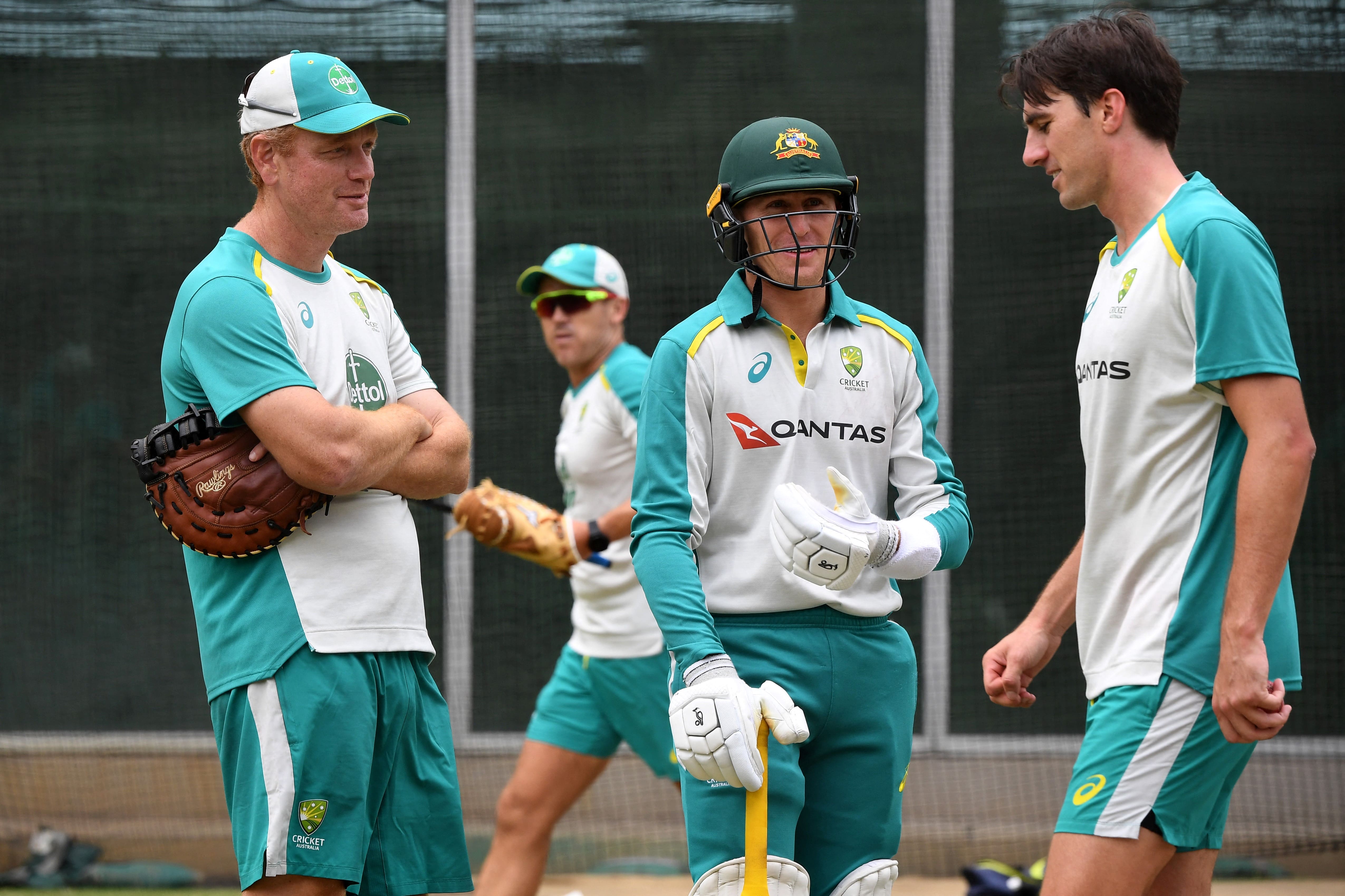 Australian cricket captain Pat Cummins (R) speaks with coach Andrew McDonald (L) and Marnus Labuschagne (C) during their final practice session at the Melbourne Cricket Ground (MCG) in Melbourne on February 25, 2022. (AFP)