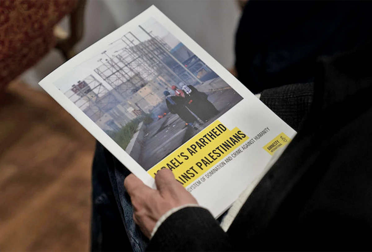 A journalist holds a copy of Amnesty International’s report “Israel’s Apartheid Against Palestinians,” at a press conference on its release in Jerusalem, on February 1, 2022. (AP)