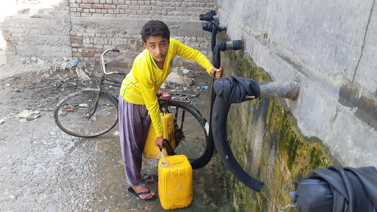 A boy fills water bottles from a public tank in Jacobabad, Pakistan, on August 19, 2021. (AN photo by Zulfiqar Kunbhar)