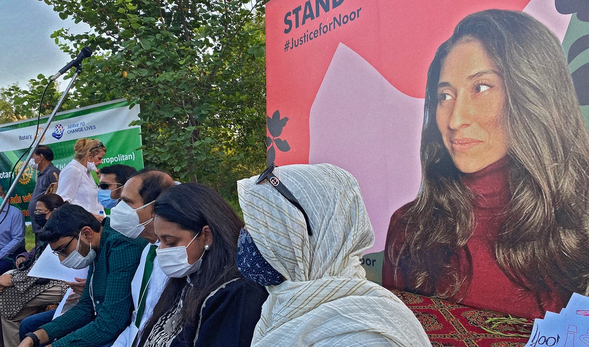 Family members of Noor Mukadam sit in front of a poster with her photo during a vigil in Islamabad, Pakistan on September 22, 2021. (AN photo/File)