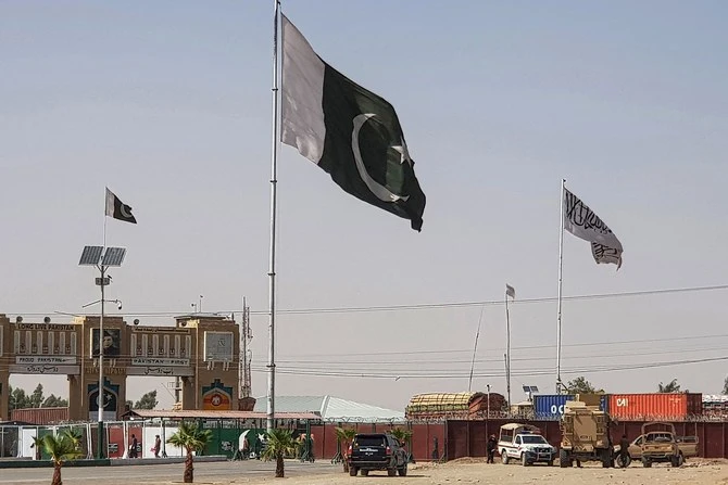 Pakistani flags (C) and Taliban flag (R) flutter on their respective border sides as seen from the Pakistan-Afghanistan border crossing point in Chaman on August 18, 2021. (AFP)