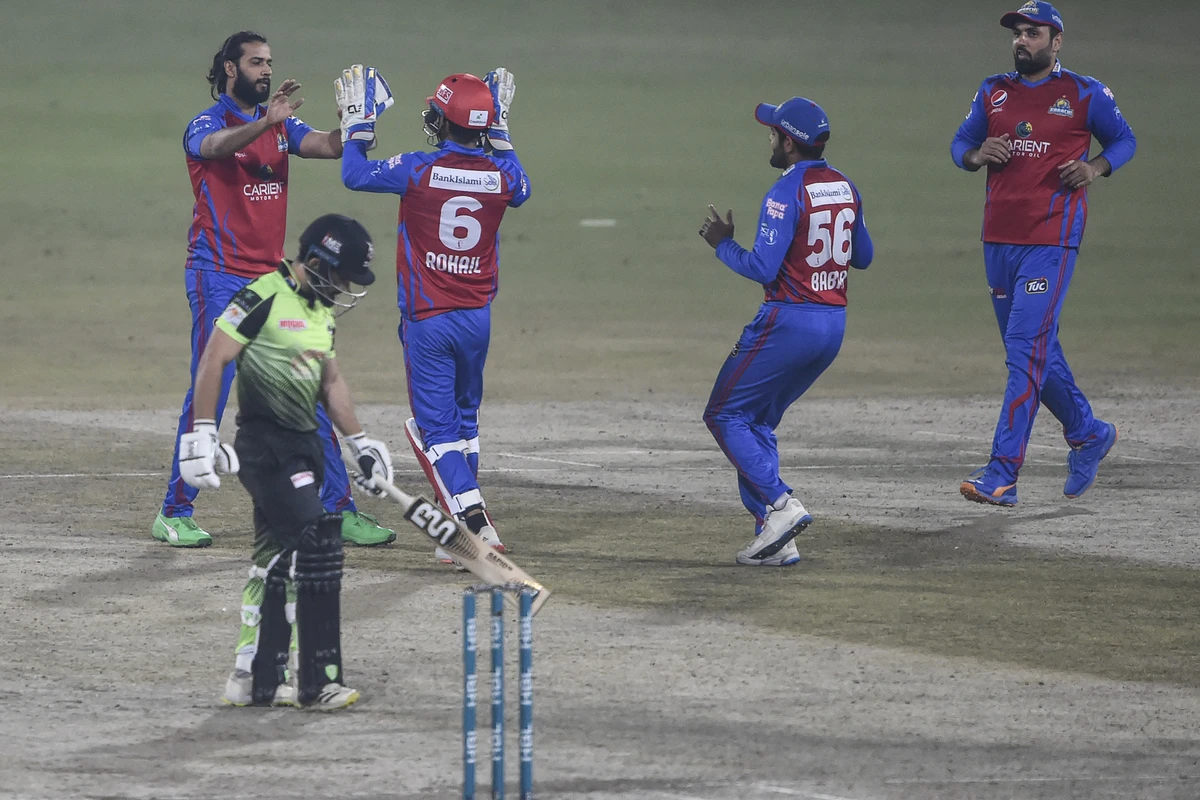 Karahci Kings' players celebrate after the dismissal of Lahore Qalandars' Kamran Ghulam (L) during the Pakistan Super League (PSL) Twenty20 cricket match between Lahore Galandars and Karachi Kings at the Gaddafi Cricket Stadium in Lahore on February 18, 2022. (AFP)