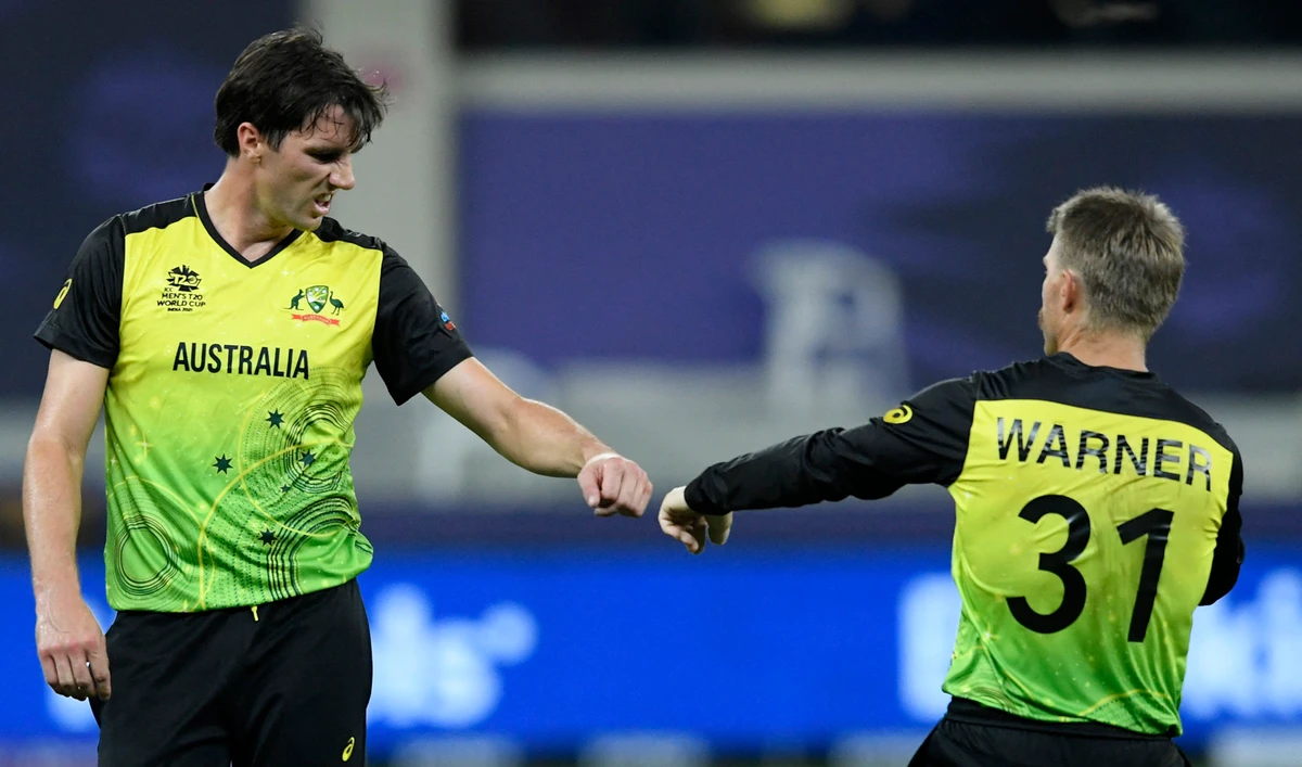 Australia's Pat Cummins, left, and David Warner celebrate wicket of Sri Lanka's captain Dasun Shanaka during the ICC men’s Twenty20 World Cup cricket match at the Dubai International Cricket Stadium on October 28, 2021. (AFP/File)