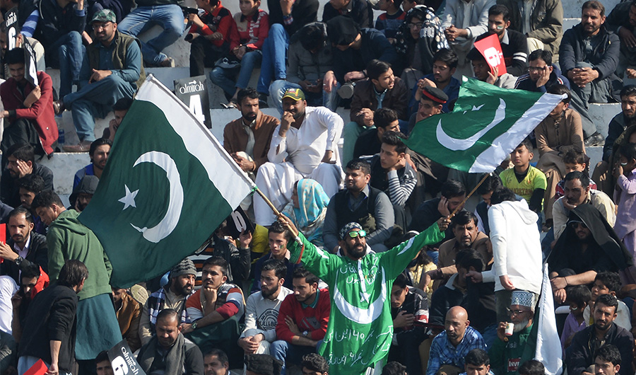 A spectator waves Pakistani flags during the third day of the first cricket Test match between Pakistan and Bangladesh at the Rawalpindi Cricket Stadium in Rawalpindi on February 9, 2020. (AFP/FILE)
