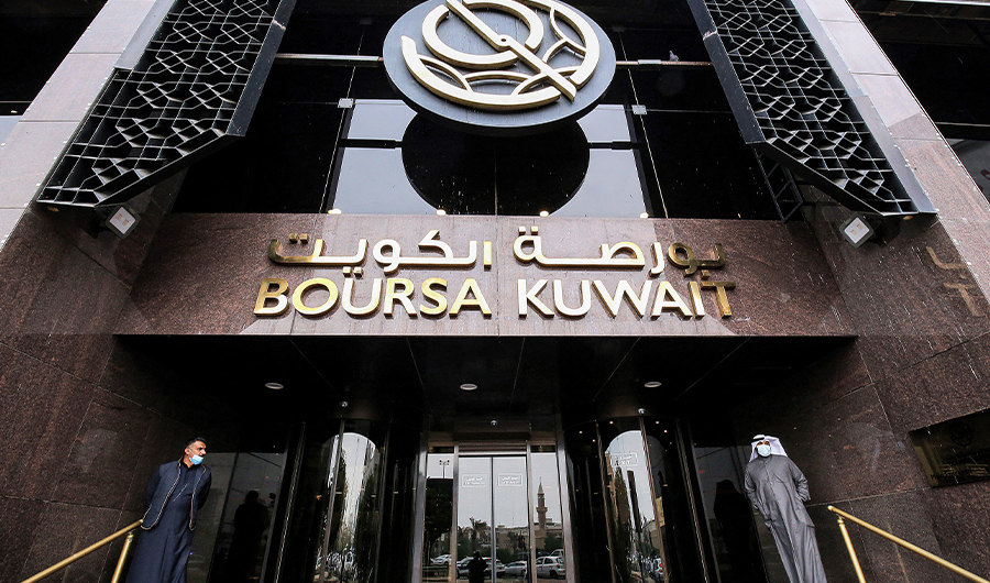 Traders, mask-clad due to the COVID-19 coronavirus pandemic, stand at the entrance of the Boursa Kuwait (Kuwait's national stock exchange) building on Dec 1, 2020. (AFP/FILE)