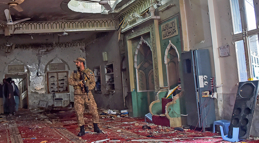 A soldier stands guard inside a mosque after a bomb blast in Peshawar on March 4, 2022. (AFP)