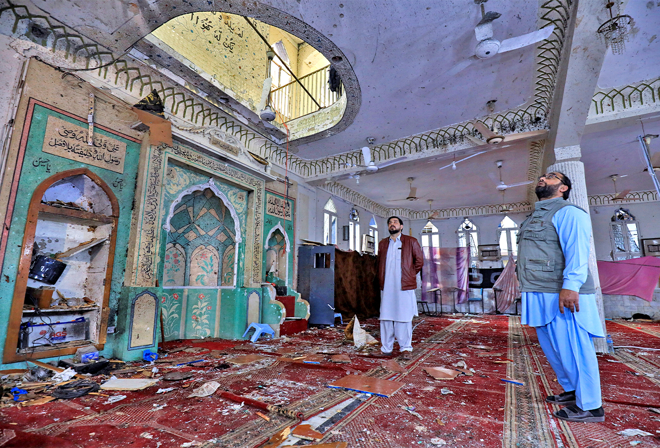 People stand amid the damages at the prayer hall after a bomb blast inside a mosque during Friday prayers in Peshawar, Pakistan, on March 4, 2022. (REUTERS)
