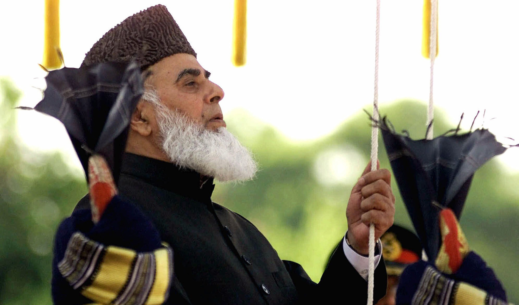 Former Pakistani President Rafiq Tarar hoists the Pakistani flag at the Presidential palace in Islamabad on August 14, 2000. (AP/File)
