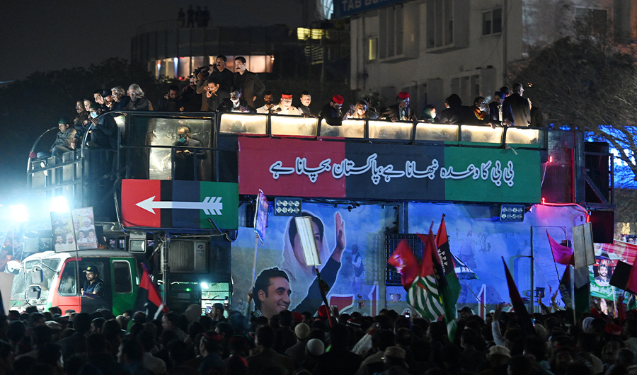 Supporters of opposition Pakistan Peoples Party (PPP) gather around a truck carrying Chairman of PPP Bilawal Bhutto Zardari, leading an anti-government rally in Islamabad on March 8, 2022. (AFP)