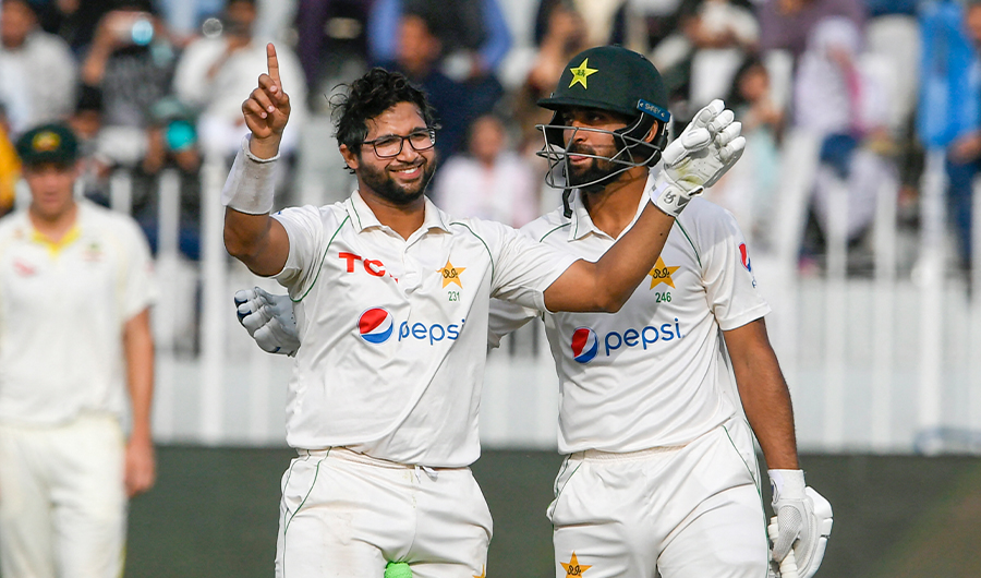 Pakistan's Imam-ul-Haq (L) celebrates after scoring a century (100 runs) during the fifth day of the first Test cricket match between Pakistan and Australia in Rawalpindi on March 8, 2022. (AFP)