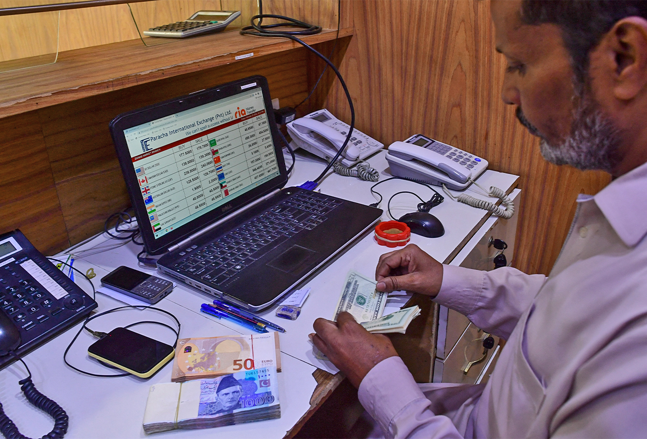 A currency dealer counts US dollar bills at a shop in Karachi, Pakistan, on February 25, 2022. (AFP/File)