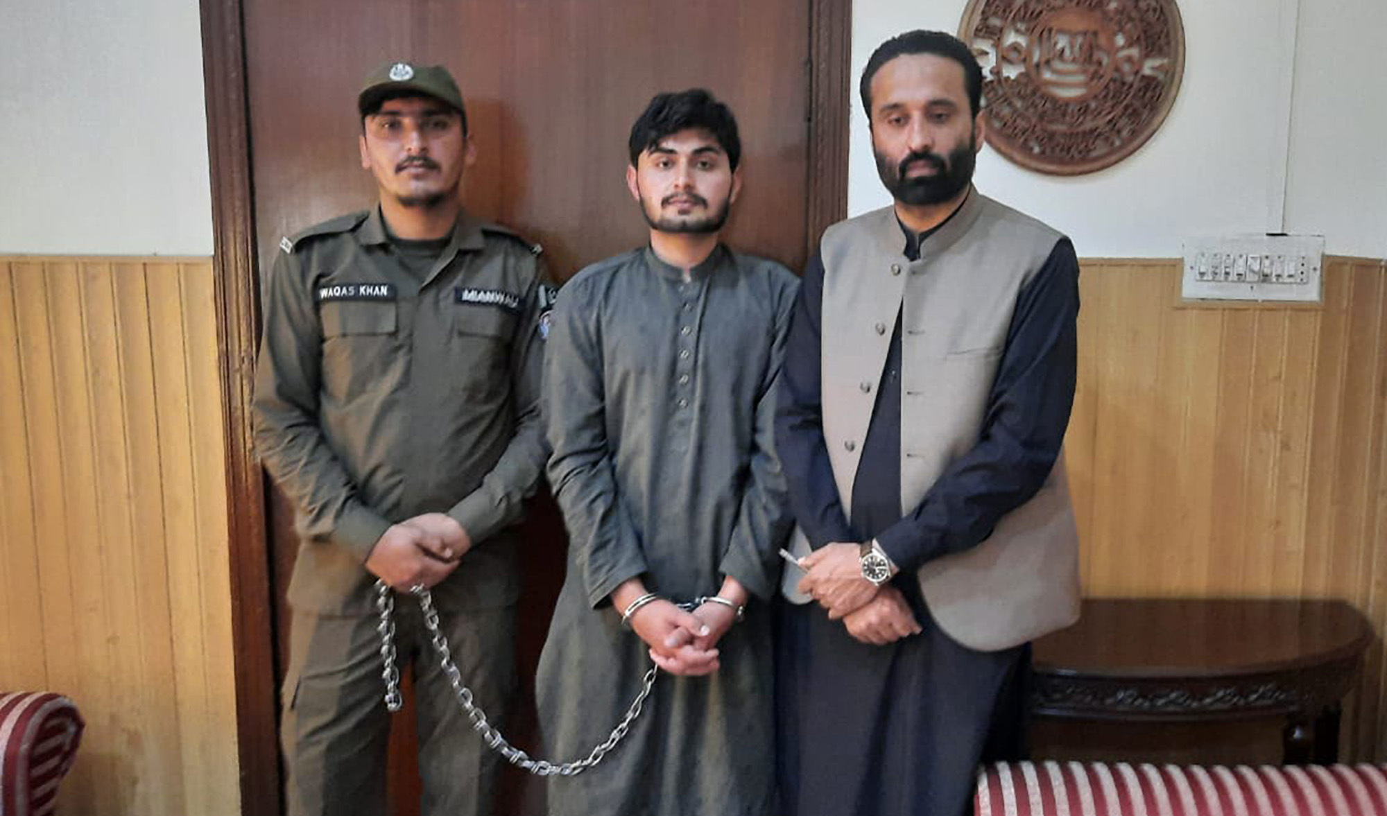 This photograph released by Punjab Police on March 10, 2022, shows man suspected killing his seven-day-old daughter flanked by Mianwali police officers. (Photo courtesy: @OfficialDPRPP/Twitter)
