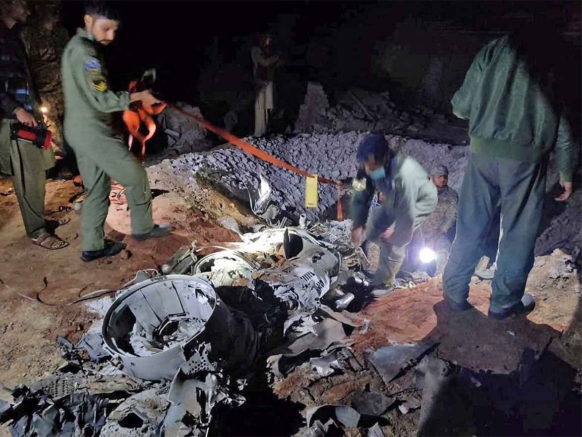People work around what Pakistani security sources say is the remains of a missile fired into Pakistan from India, near Mian Channu, Pakistan, on March 9, 2022. (REUTERS)