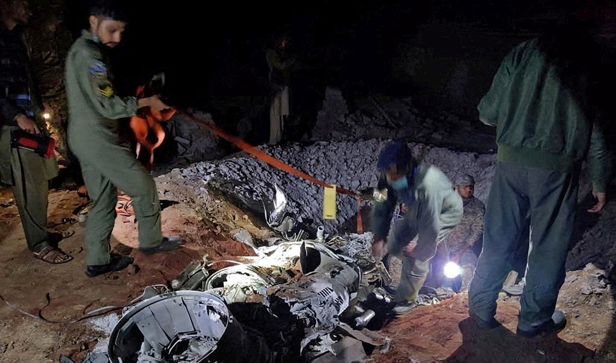 People work around remains of a missile fired into Pakistan from India, near Mian Chunnu, Pakistan, on March 9, 2022. (Pakistani security sources via REUTERS)