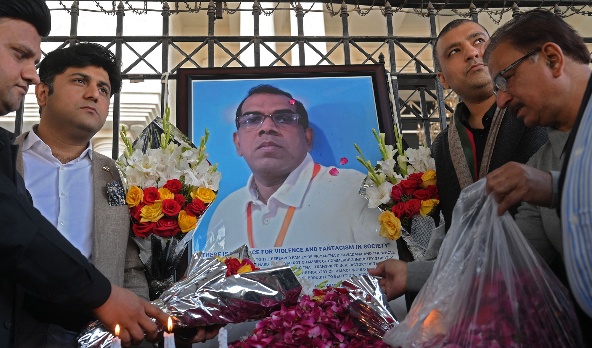 Pakistani industrialists pay tribute beside a photograph of slain Sri Lankan factory manager Priyantha Kumara, in Sialkot on December 4, 2021. (AFP/File)