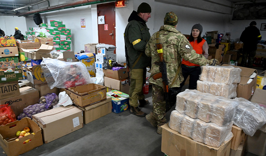 Soldiers of the Territorial Defense Forces of Ukraine, the military reserve of the Armed Forces of Ukraine, receive food in the warehouse in Kyiv on March 11, 2022. (AFP)