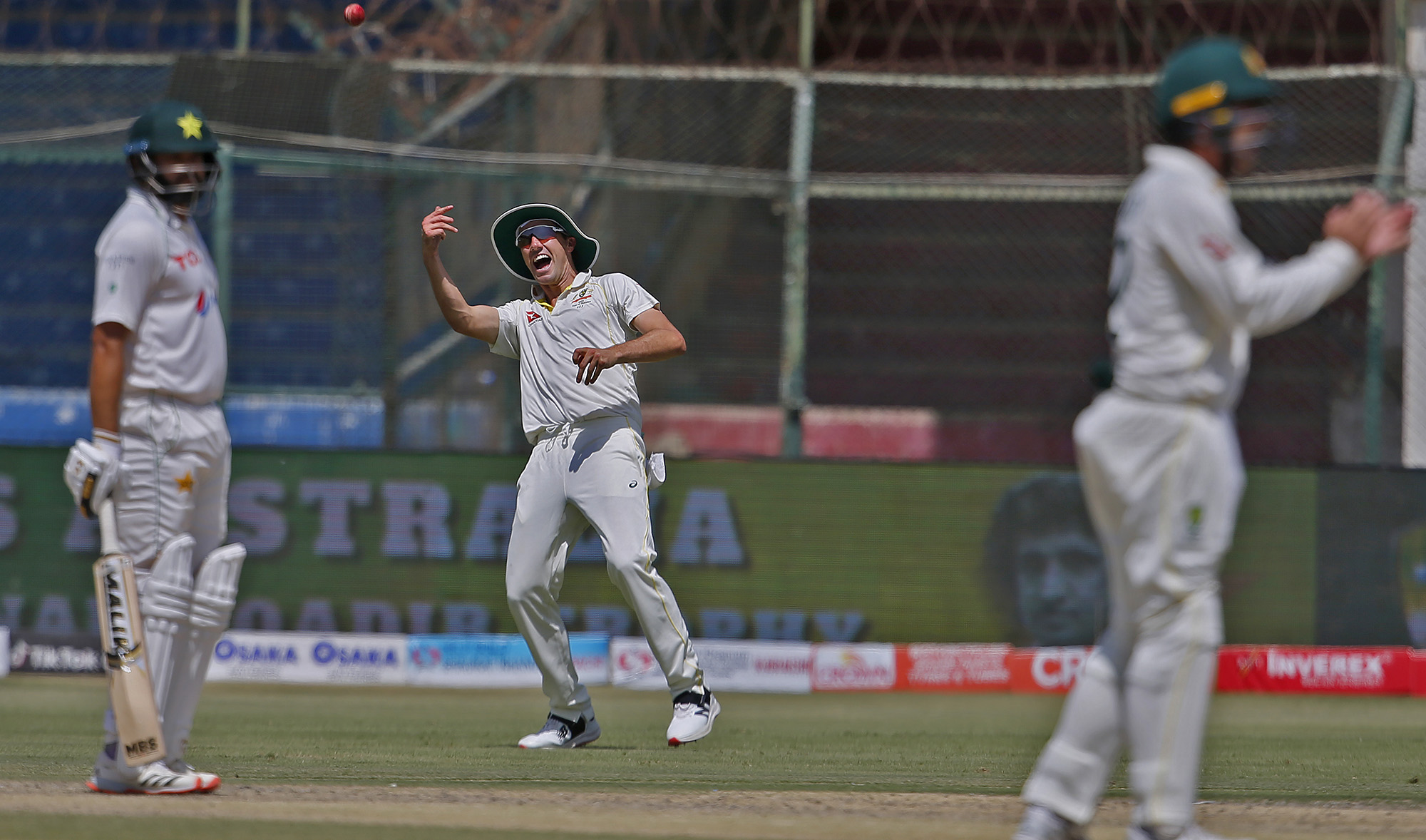 Australia's Pat Cummins, center, celebrates after taking the catch of Pakistan Imam-ul-Haq during the third day of the second test at the National Stadium in Karachi, Pakistan on March 14, 2022. (AP)