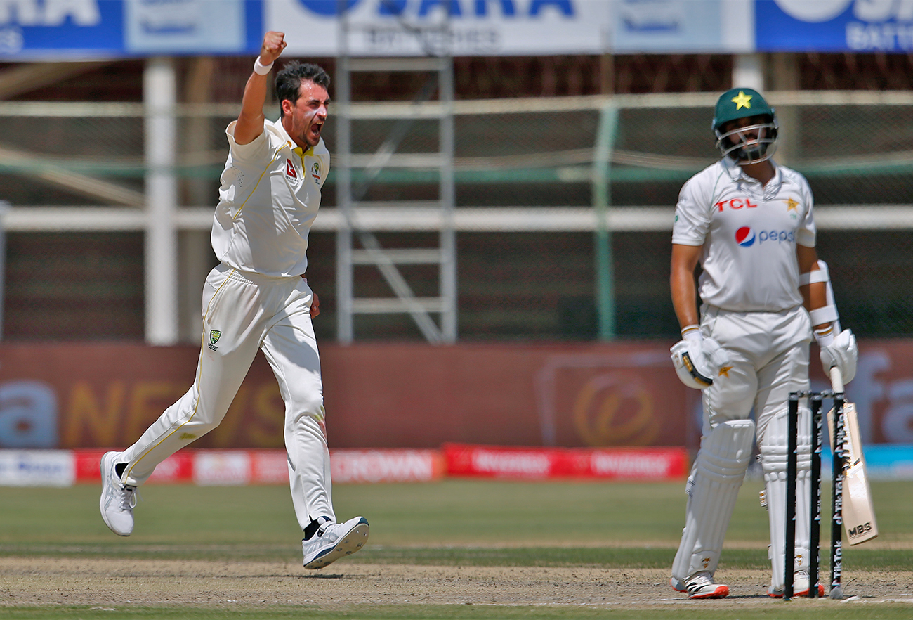 Australia's Mitchell Starc, left, celebrates after taking the wicket of Pakistan Azhar Ali, right, during the third day of the second test match between Pakistan and Australia in Karachi, Pakistan, on March 14, 2022. (AP)