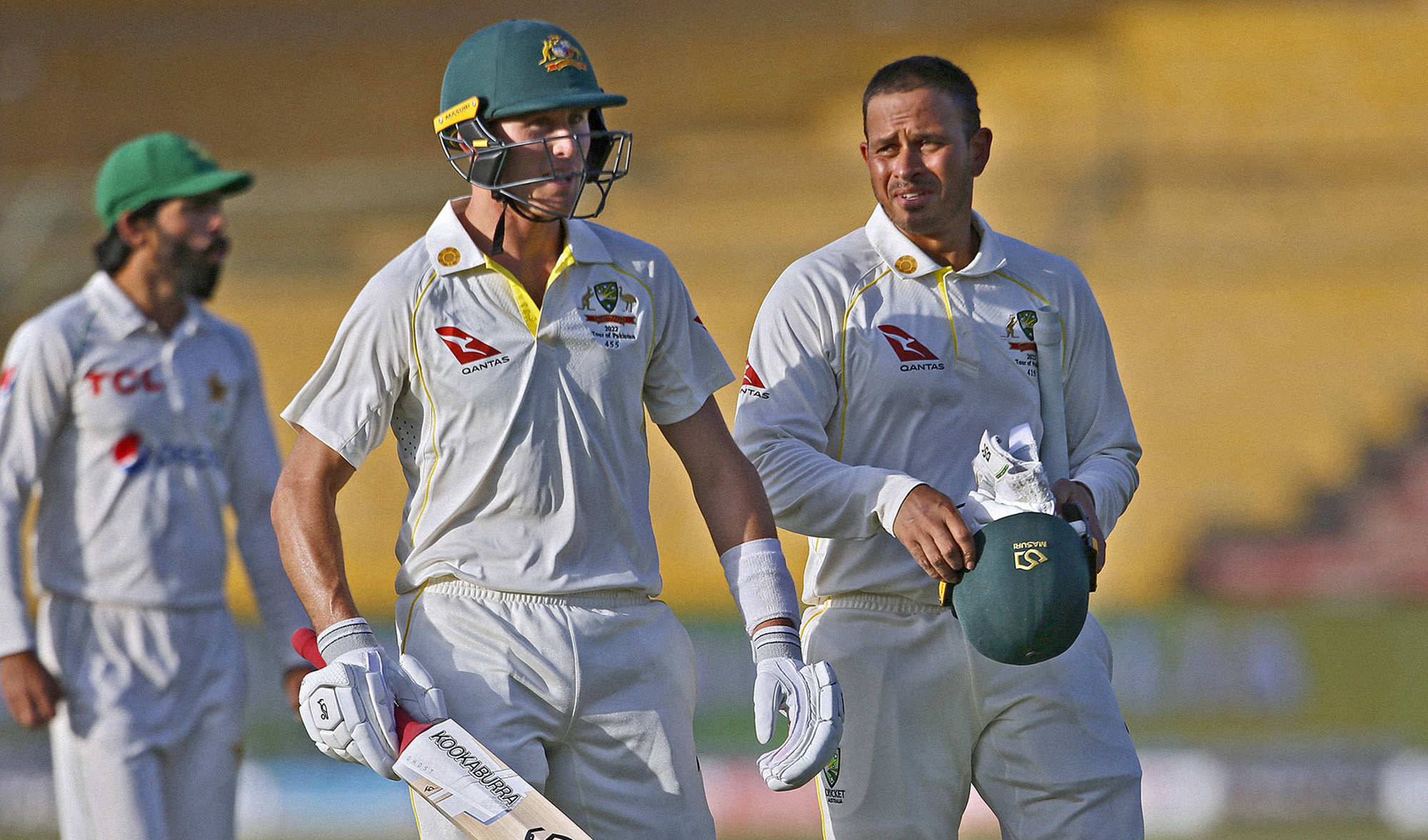 Australia's Usman Khawaja, right, and Marnus Labuschagne, center, walk back to pavilion at the end of the third day play of the second test against Pakistan at the National Stadium in Karachi, Pakistan, on March 14, 2022. (AP)